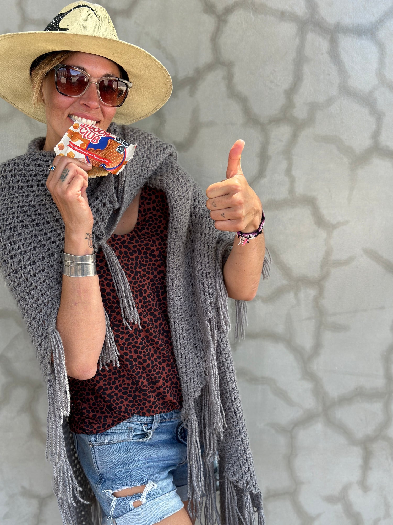 Chantal in front of a wall holding a stroop club stroopwafel package